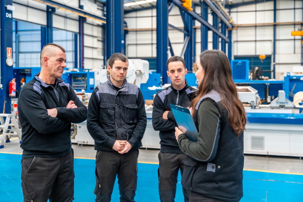 Team of industrial technicians talking standing in the facilities