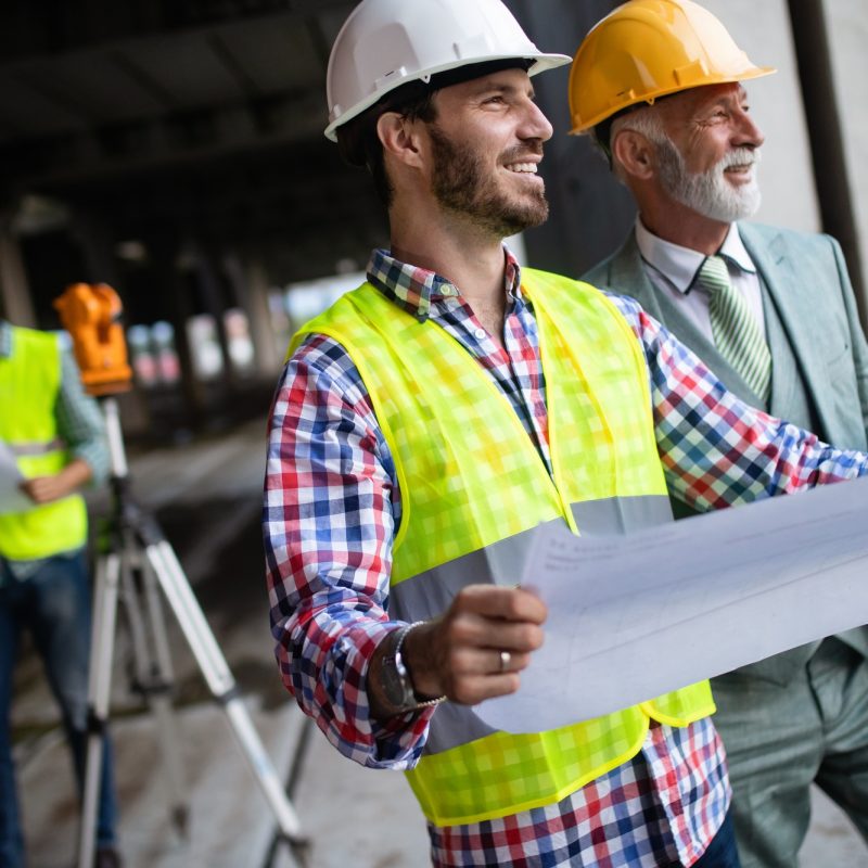 Engineer, foreman and worker discussing in building construction site