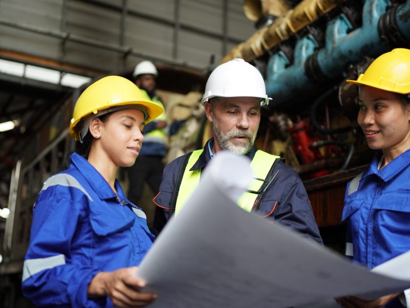 Portrait of engineer and apprentice in workshop of railway engineering facility